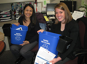 Staff holding deskside recycling bins