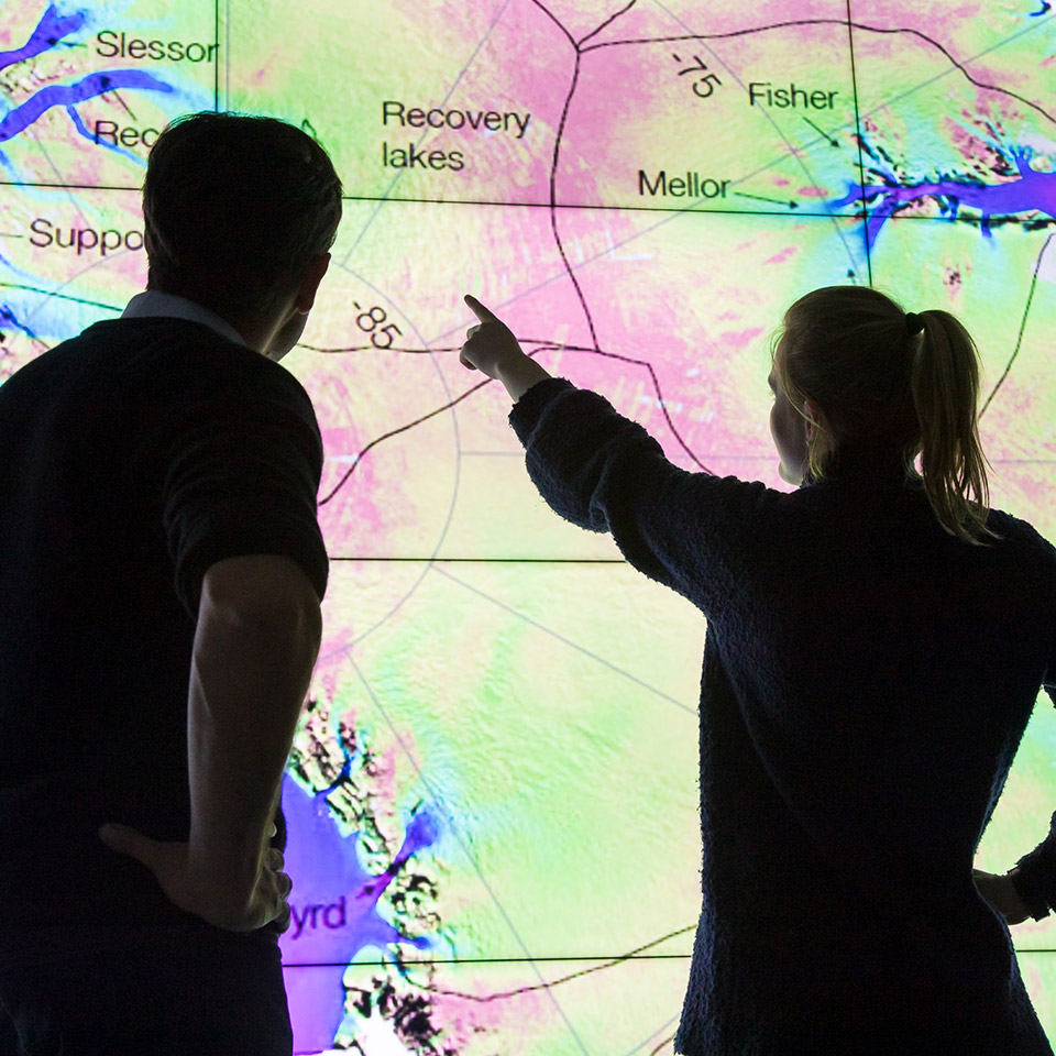 Student pointing to illuminated wall map