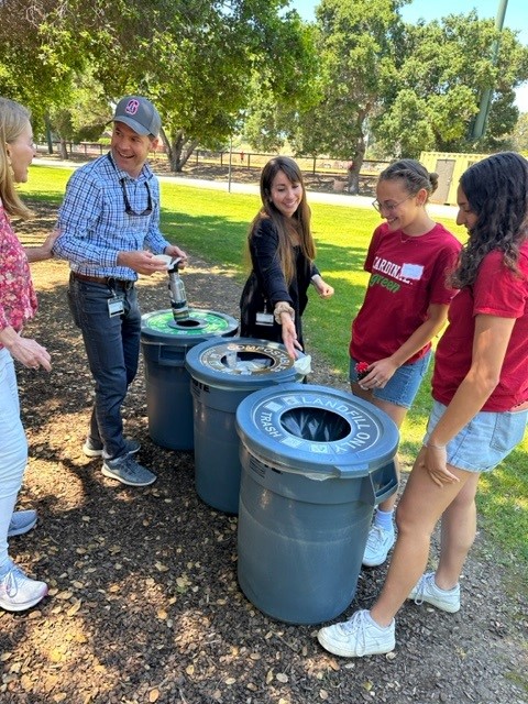 People sorting trash and recycling into bins