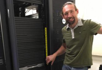 A person next to a rack of servers