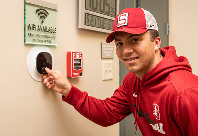 A person using an energy-saving thermostat