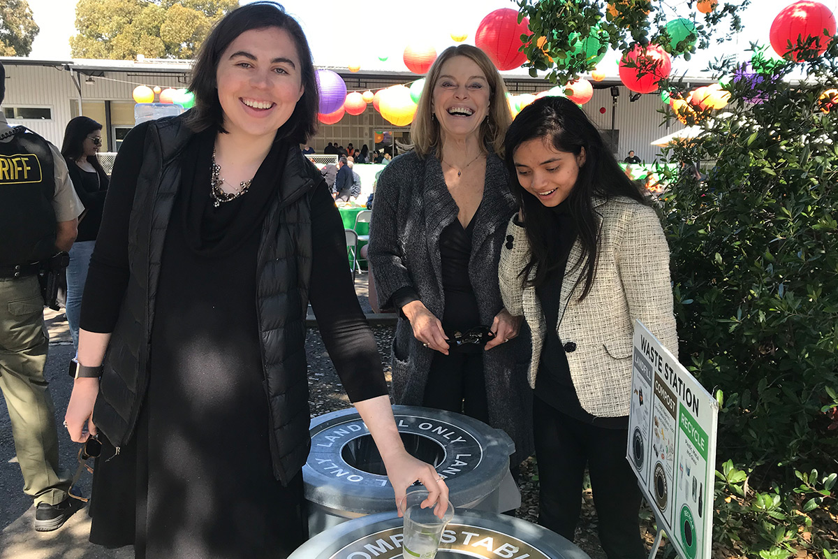 People dropping items in compost bins