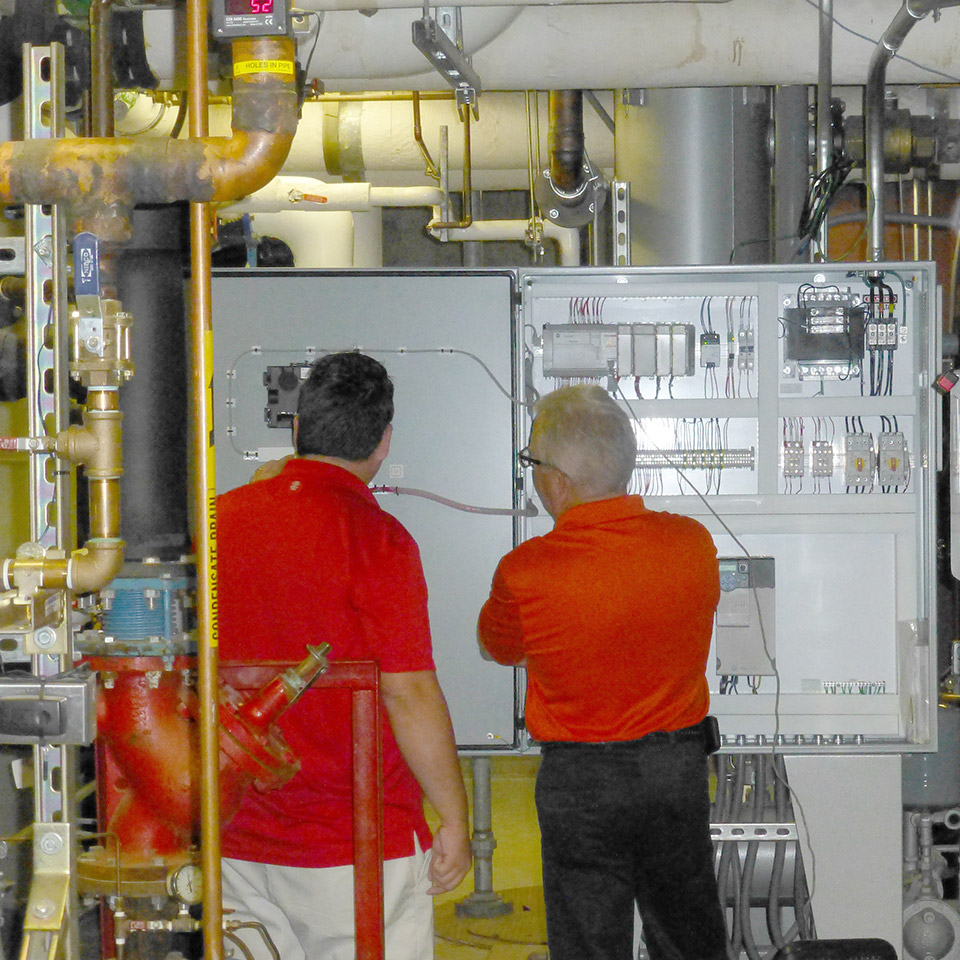 Two people inspecting a switchbox